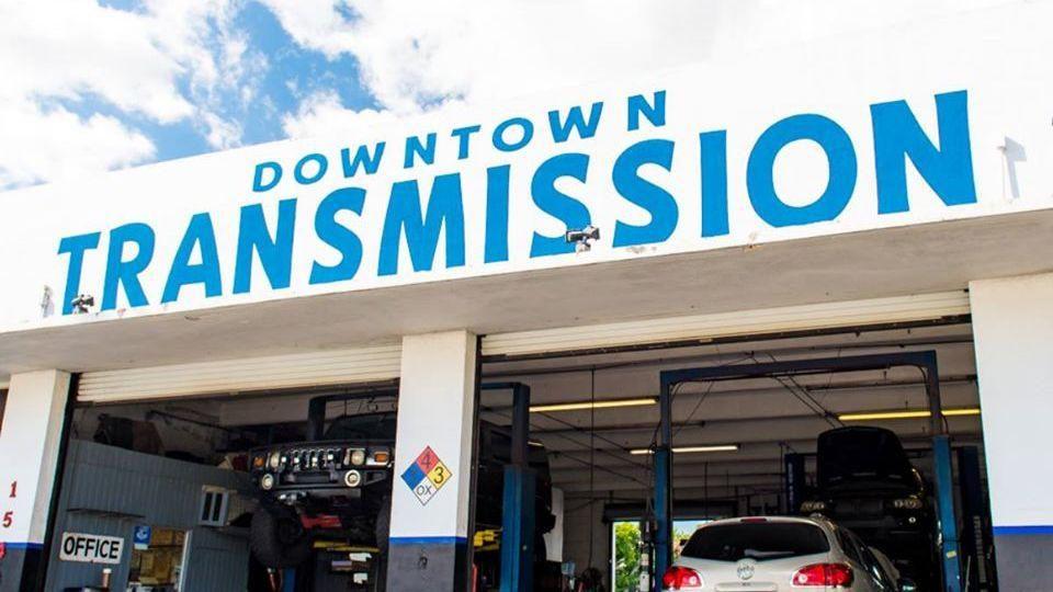 Downtown Transmission storefront with the blue painted sign and open service bays