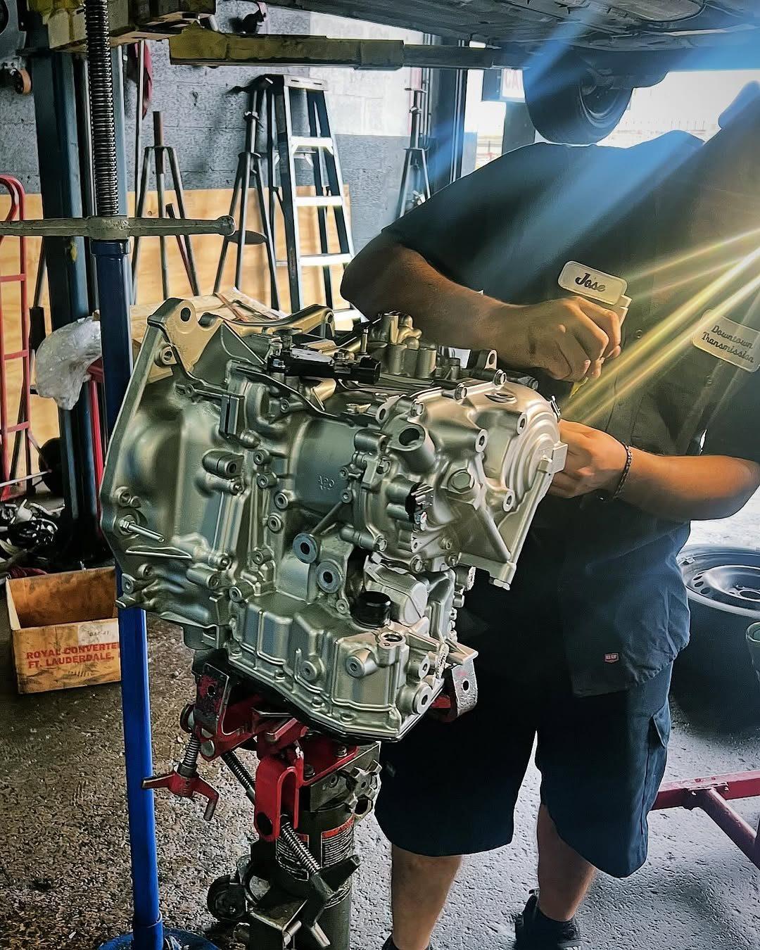 Technician holding a transmission unit on the stand